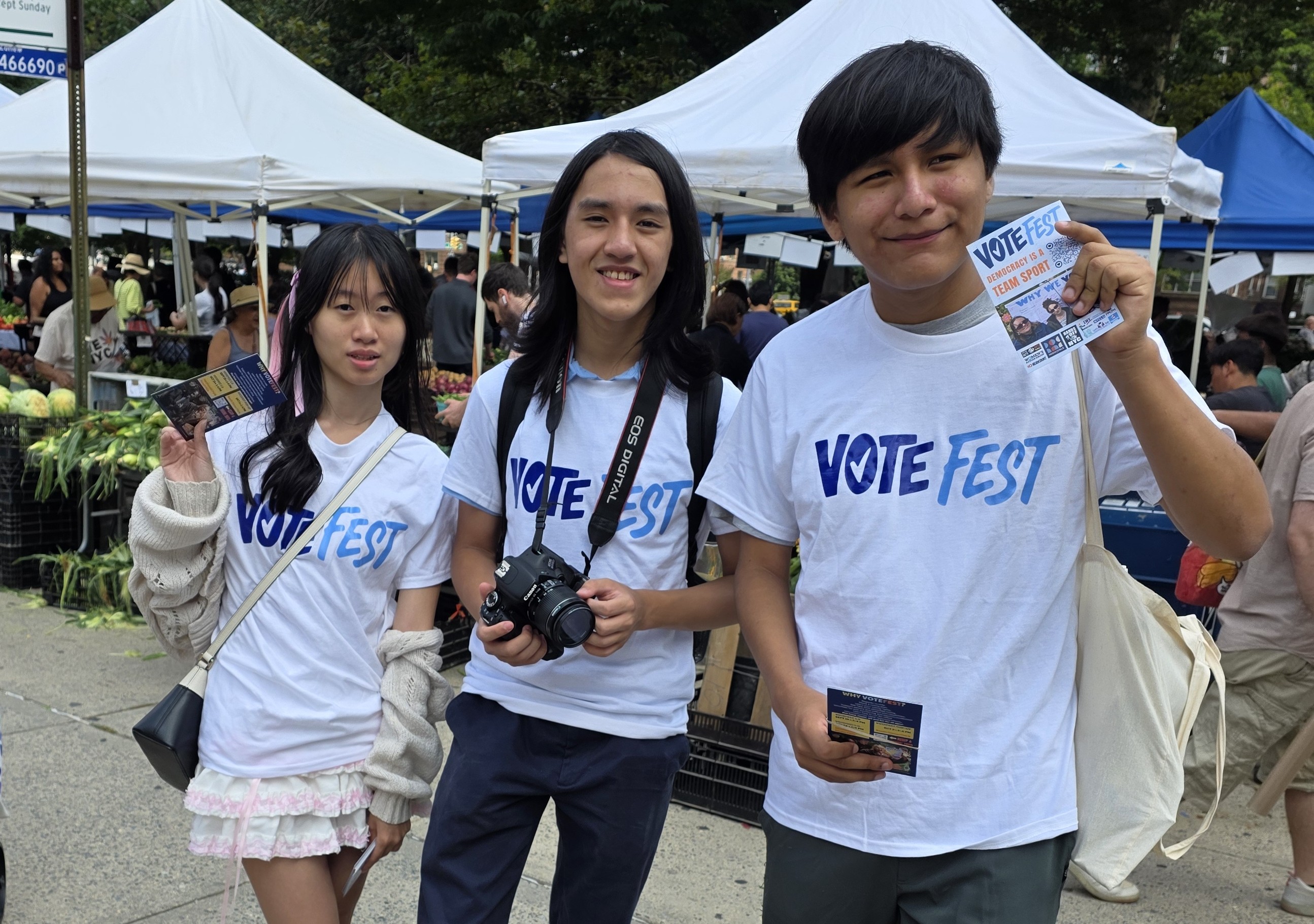 Young volunteers in VOTEFEST shirts share voting information in the neighborhood.